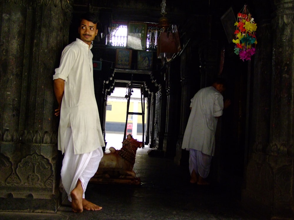 a man standing in a doorway next to another man