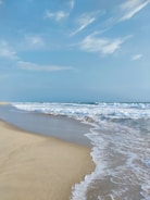 A serene beach scene with gentle waves and clear skies.
