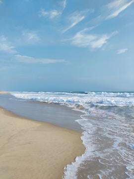 A serene beach scene with gentle waves and clear skies.