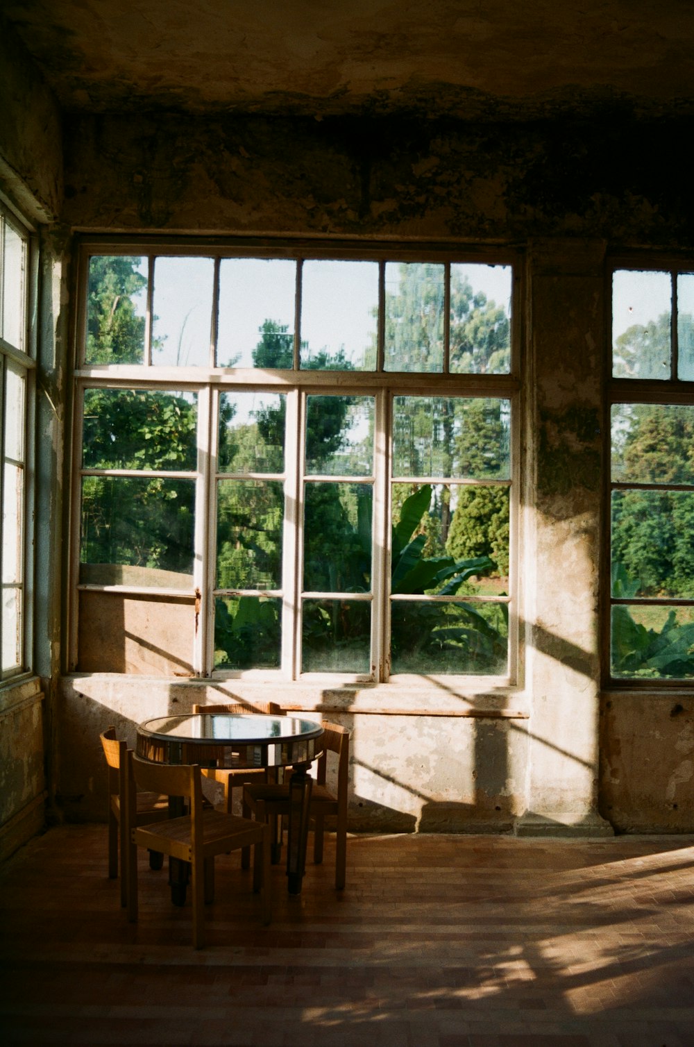 a table and chairs in a room with large windows