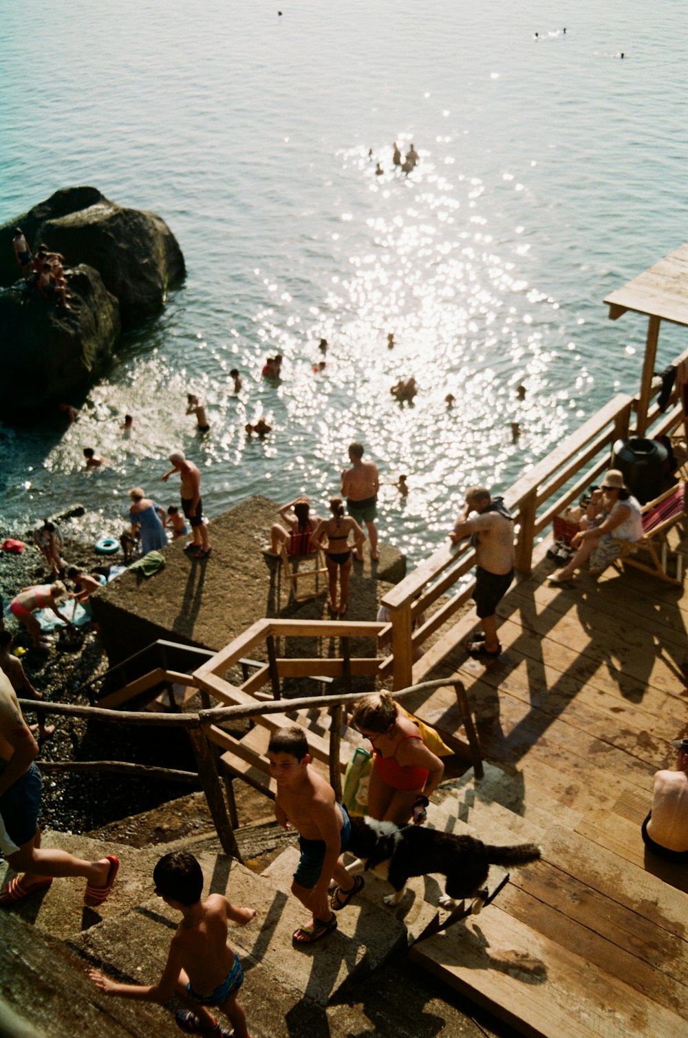 a group of people standing on top of a pier next to a body of water