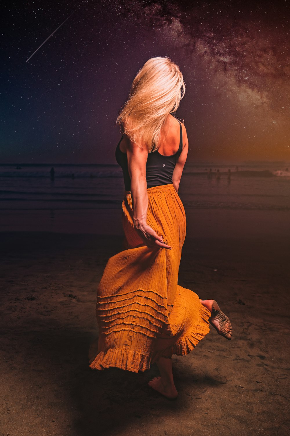 a woman in a yellow dress on the beach