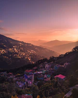 a sunset view of a small town on a hill