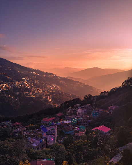 a sunset view of a small town on a hill