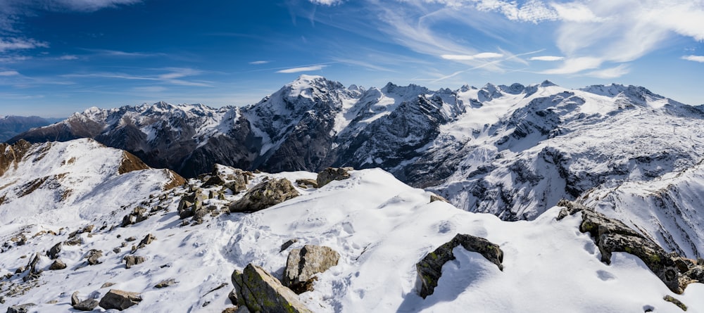 a mountain range covered in snow under a blue sky