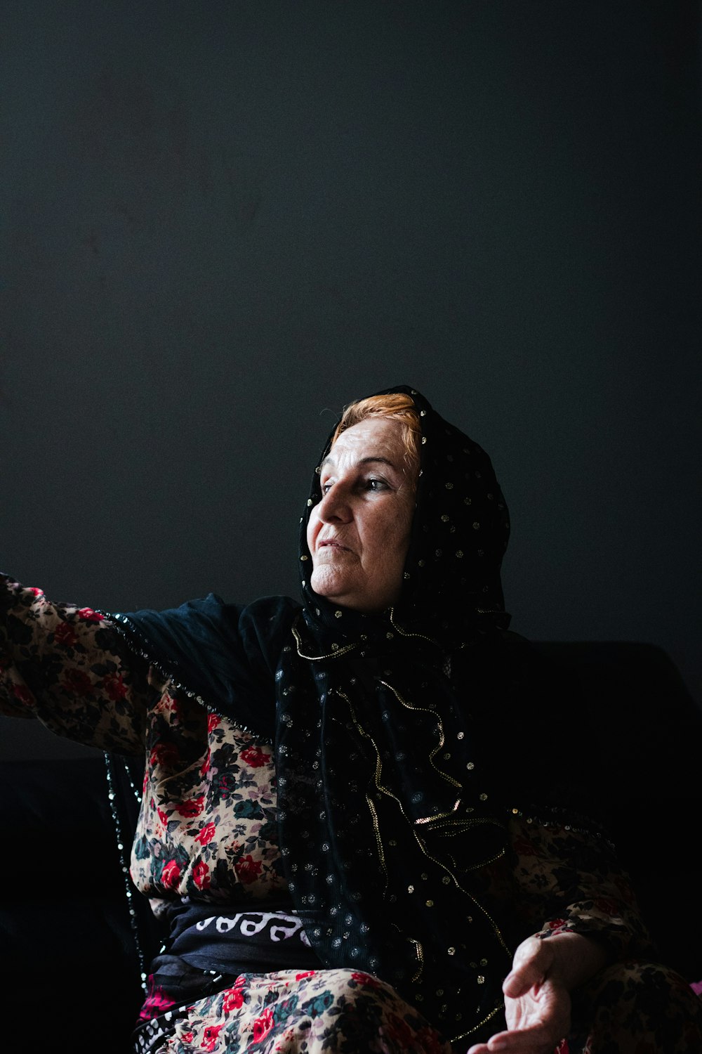 a woman sitting on a couch holding a remote control