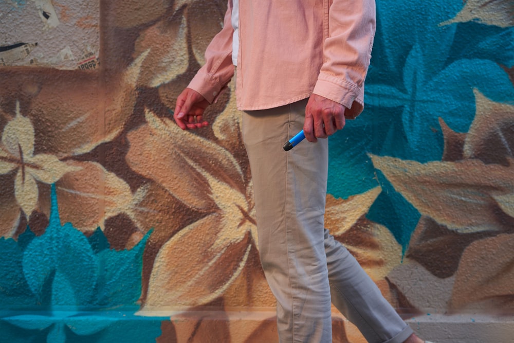 Un hombre parado frente a una pared colorida