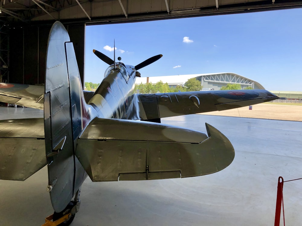 Un avión de hélice sentado dentro de un hangar