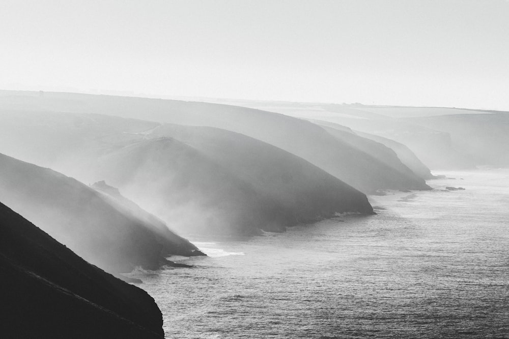a black and white photo of a foggy coastline