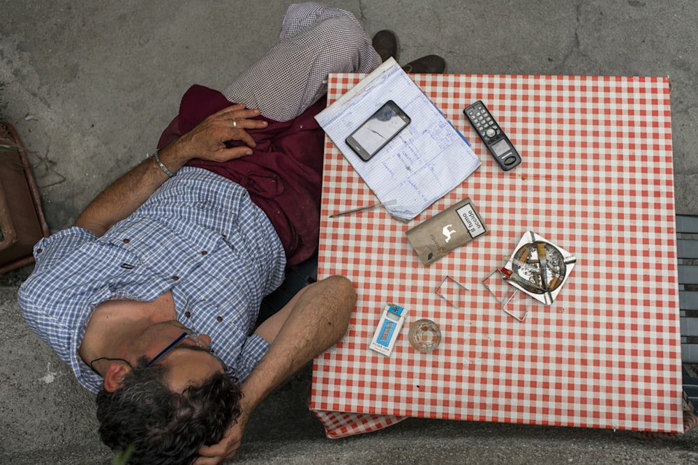 a man laying on the ground next to a table