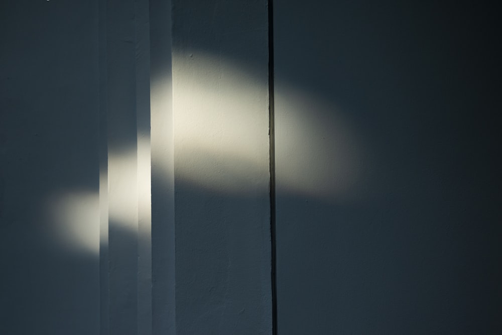 a white wall with a light shining through it