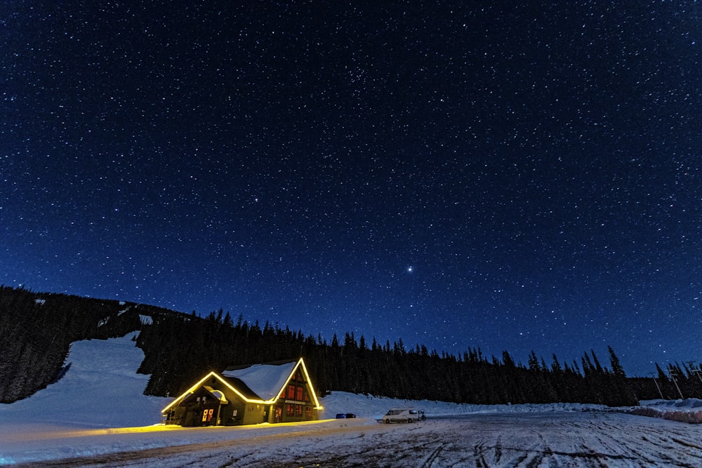 a cabin on a snowy mountain under a night sky