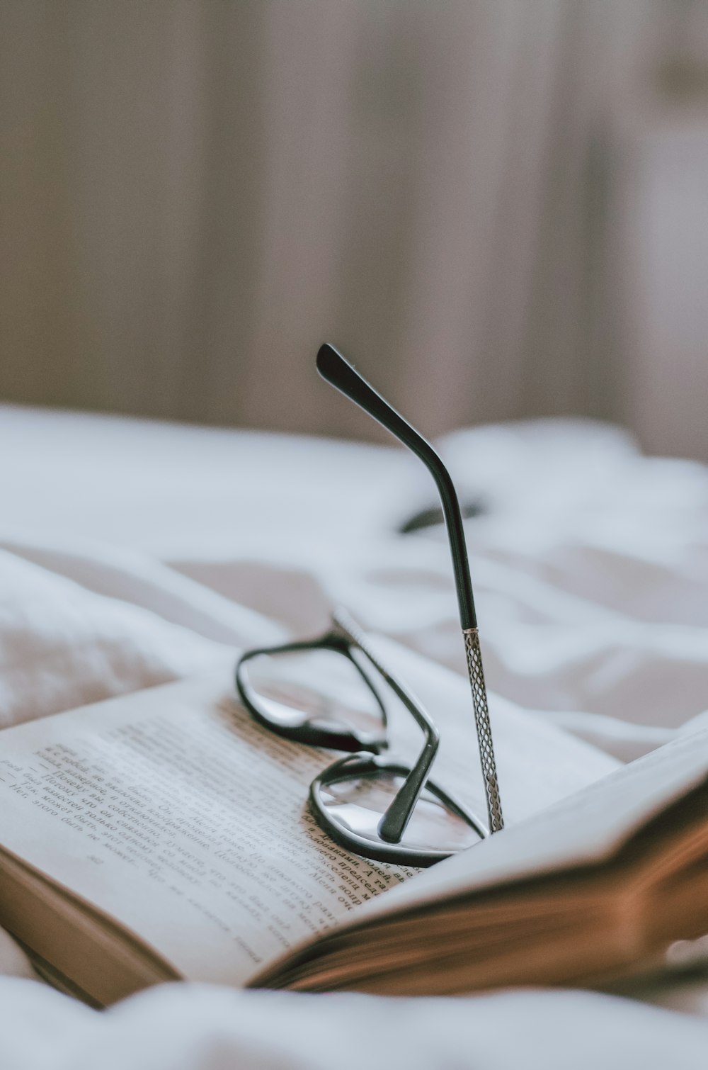 a pair of reading glasses resting on an open book