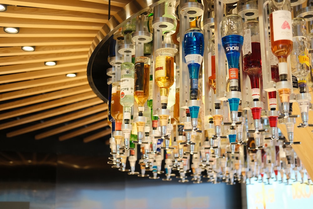 a chandelier made out of bottles hanging from a ceiling
