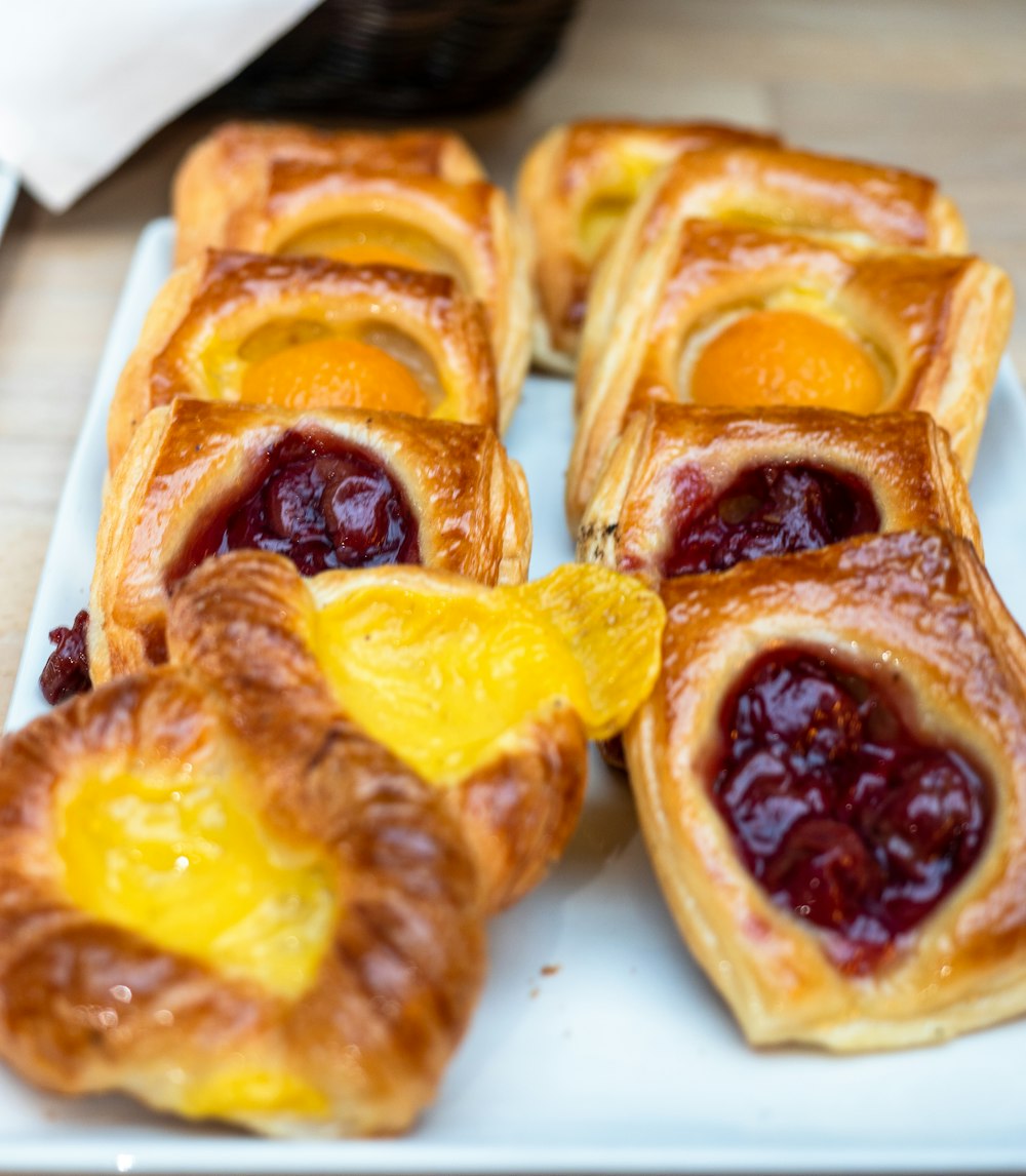 a white plate topped with pastries on top of a wooden table