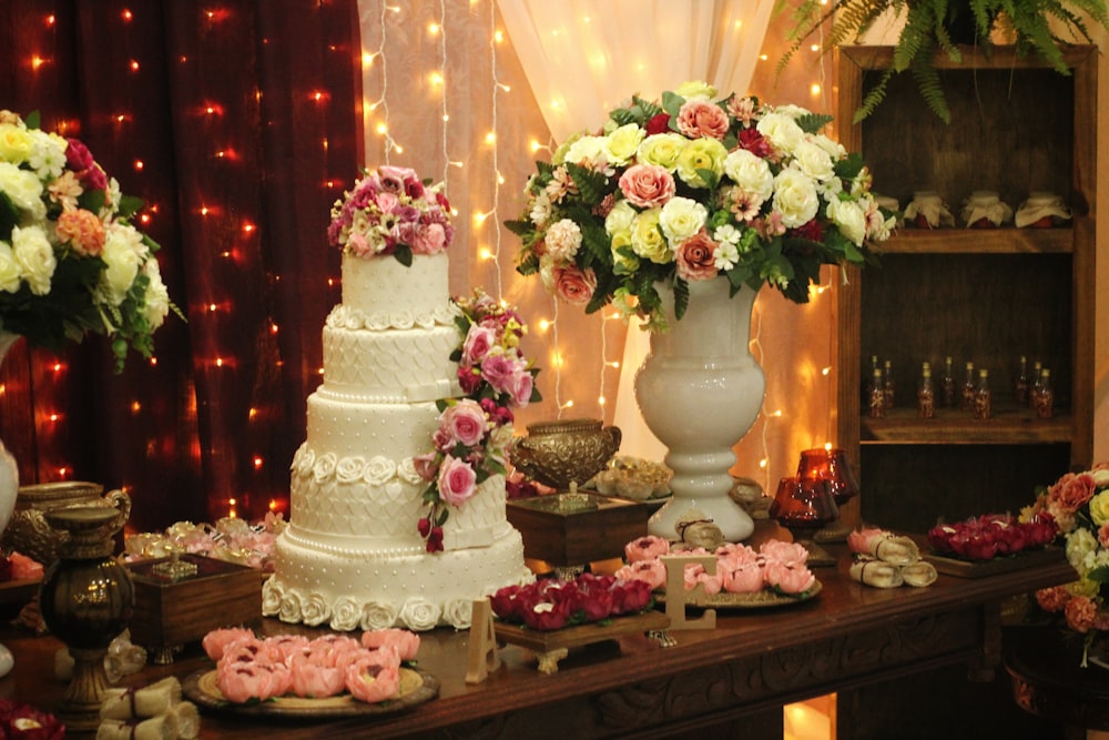 a table topped with lots of cakes and flowers