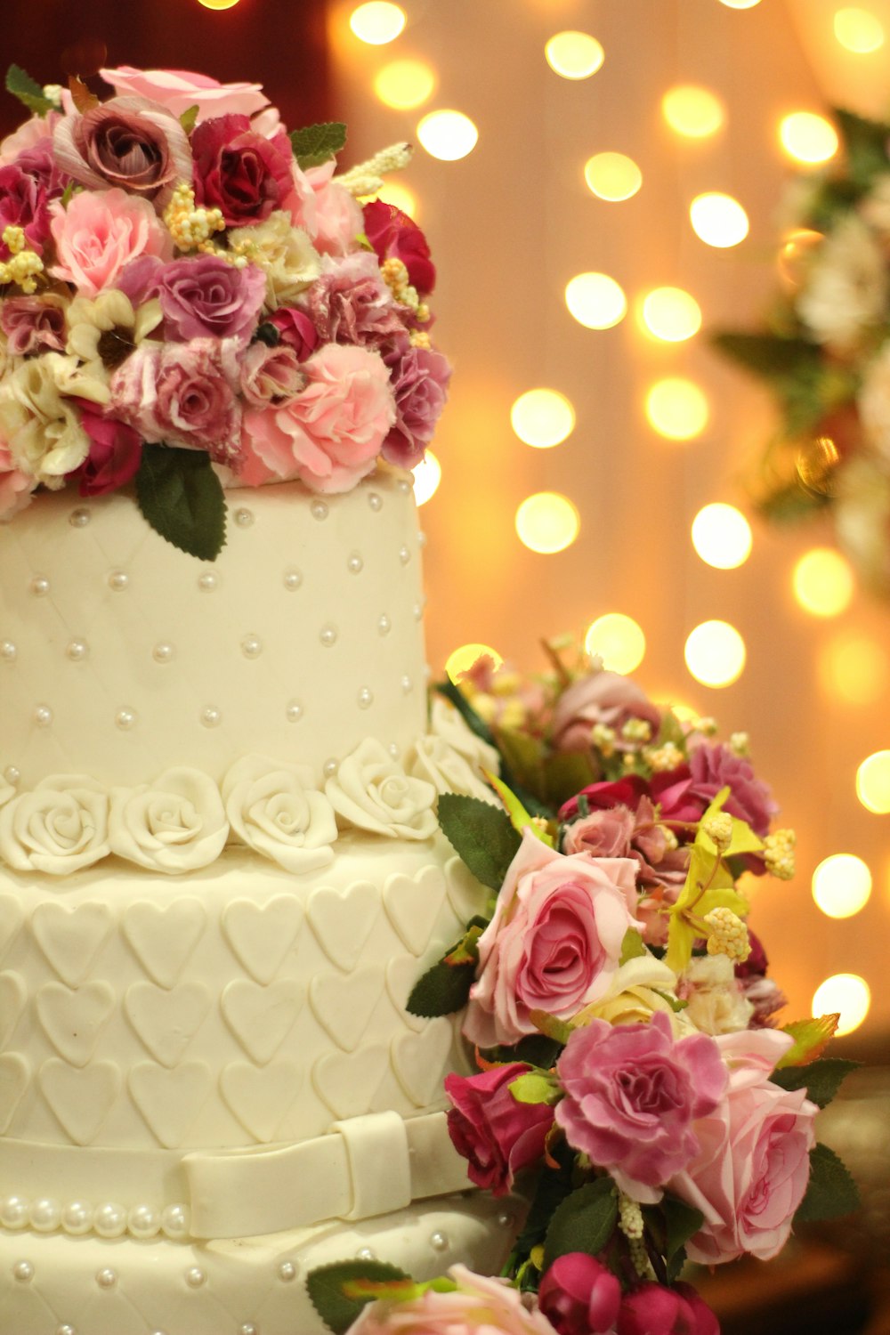 a wedding cake with pink and white flowers on top
