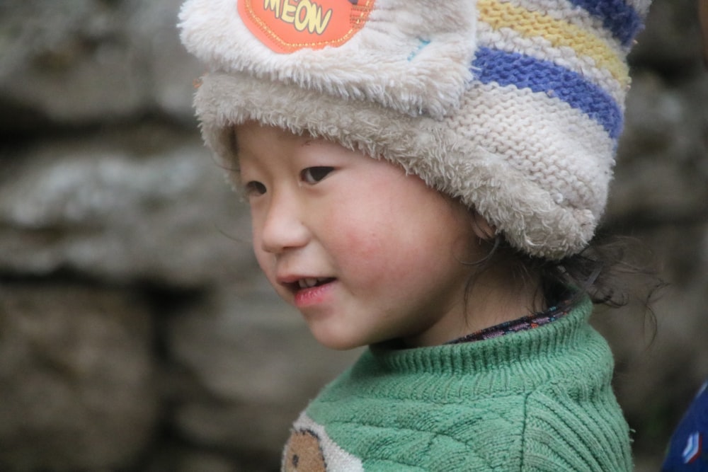 a little girl wearing a hat with a button on it