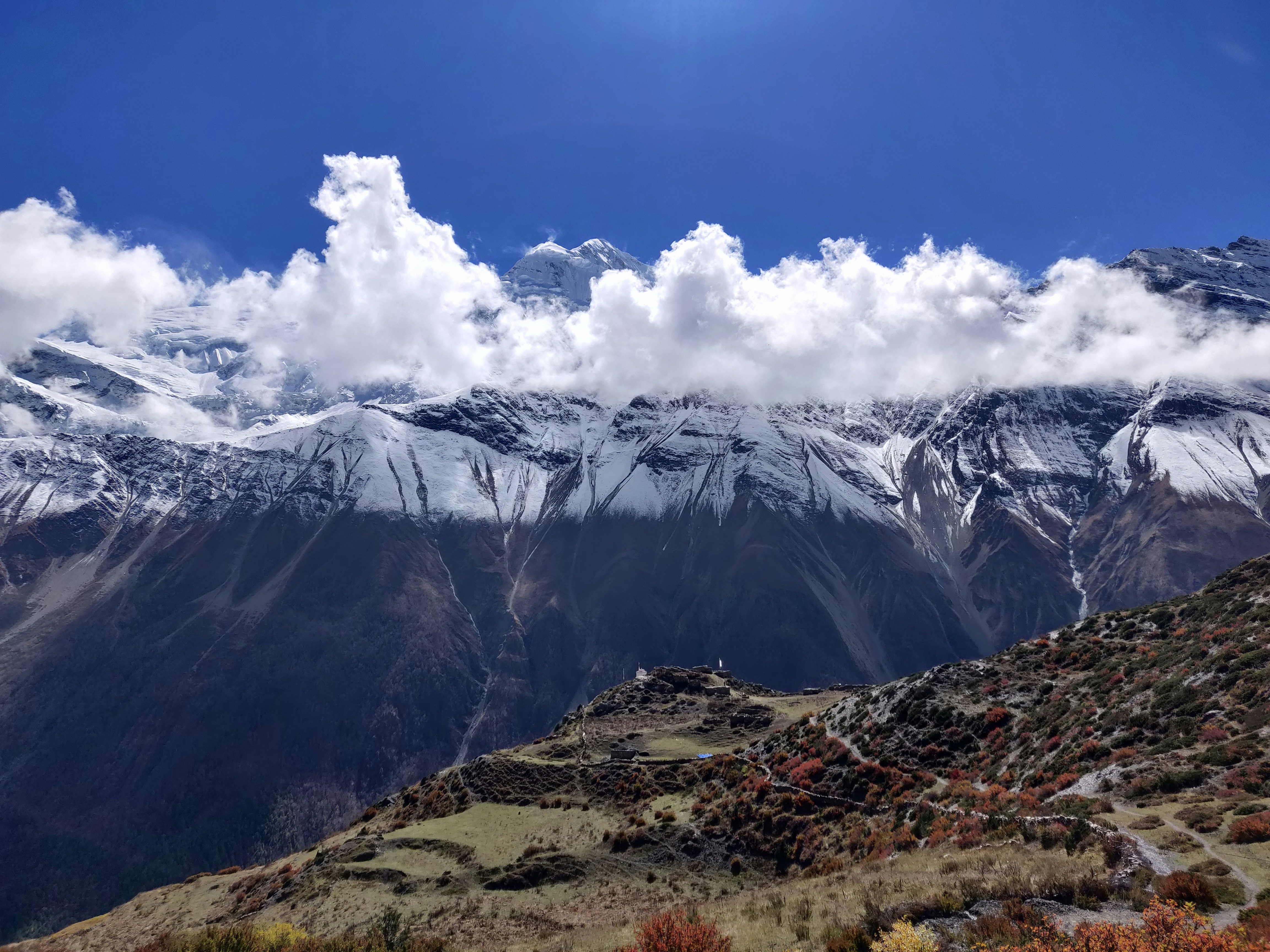 a mountain range with snow capped mountains in the background