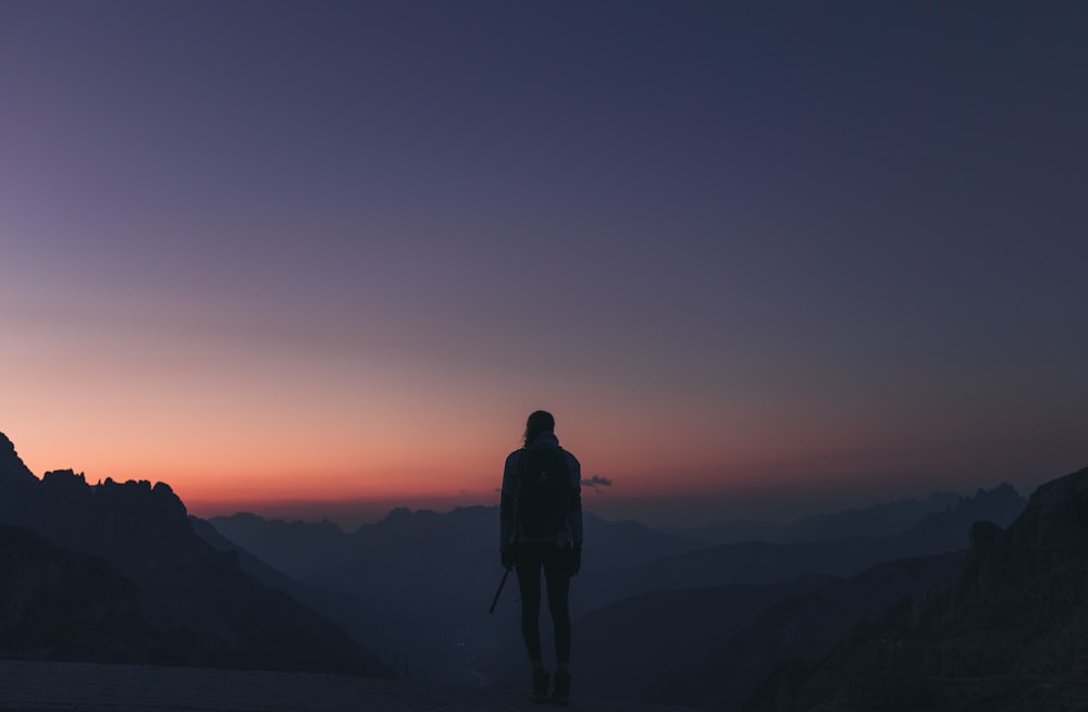 a person standing on top of a mountain at sunset