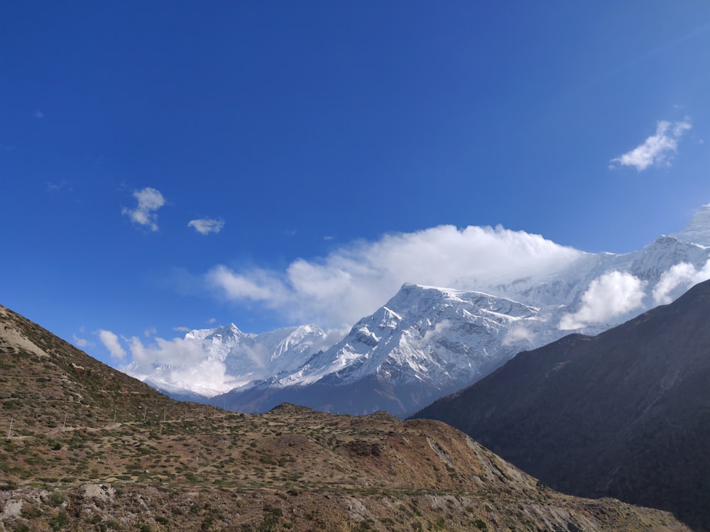 une vue d’une chaîne de montagnes avec des nuages dans le ciel