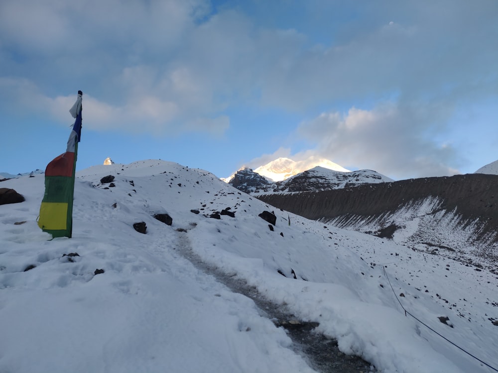 a flag on top of a snow covered mountain