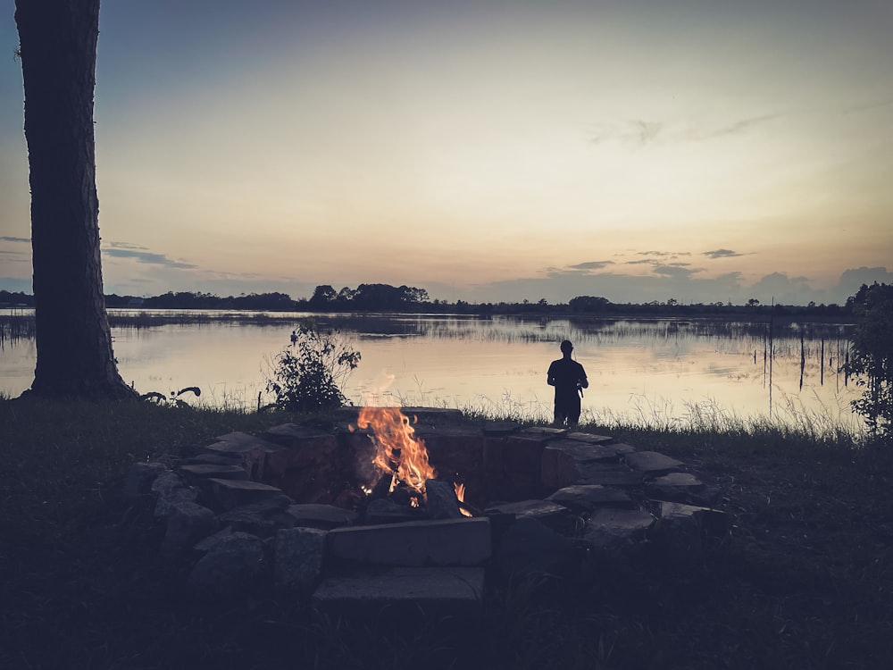 a man standing in front of a fire pit