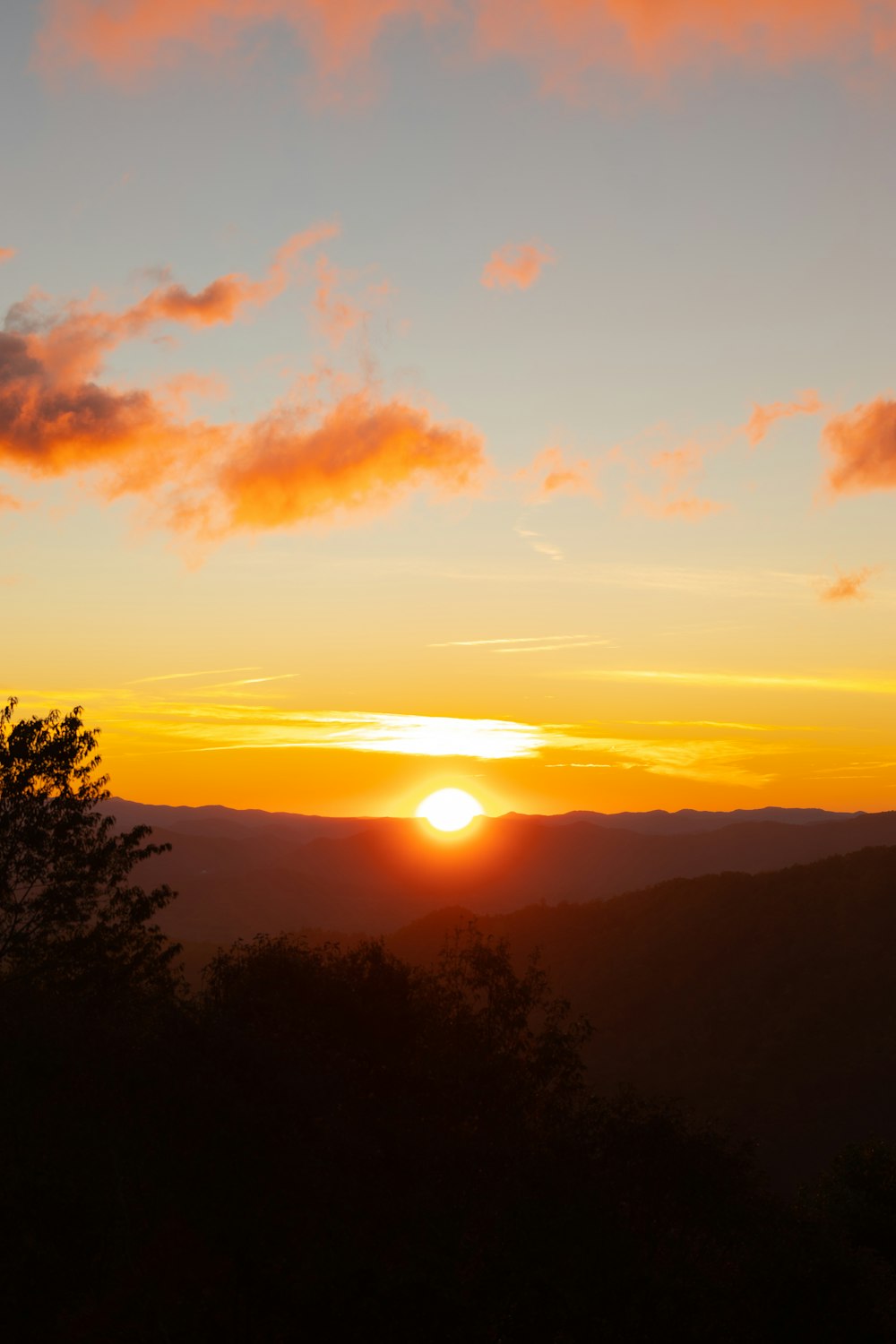 the sun is setting over a mountain range