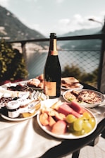 a bottle of wine sitting on top of a table filled with food