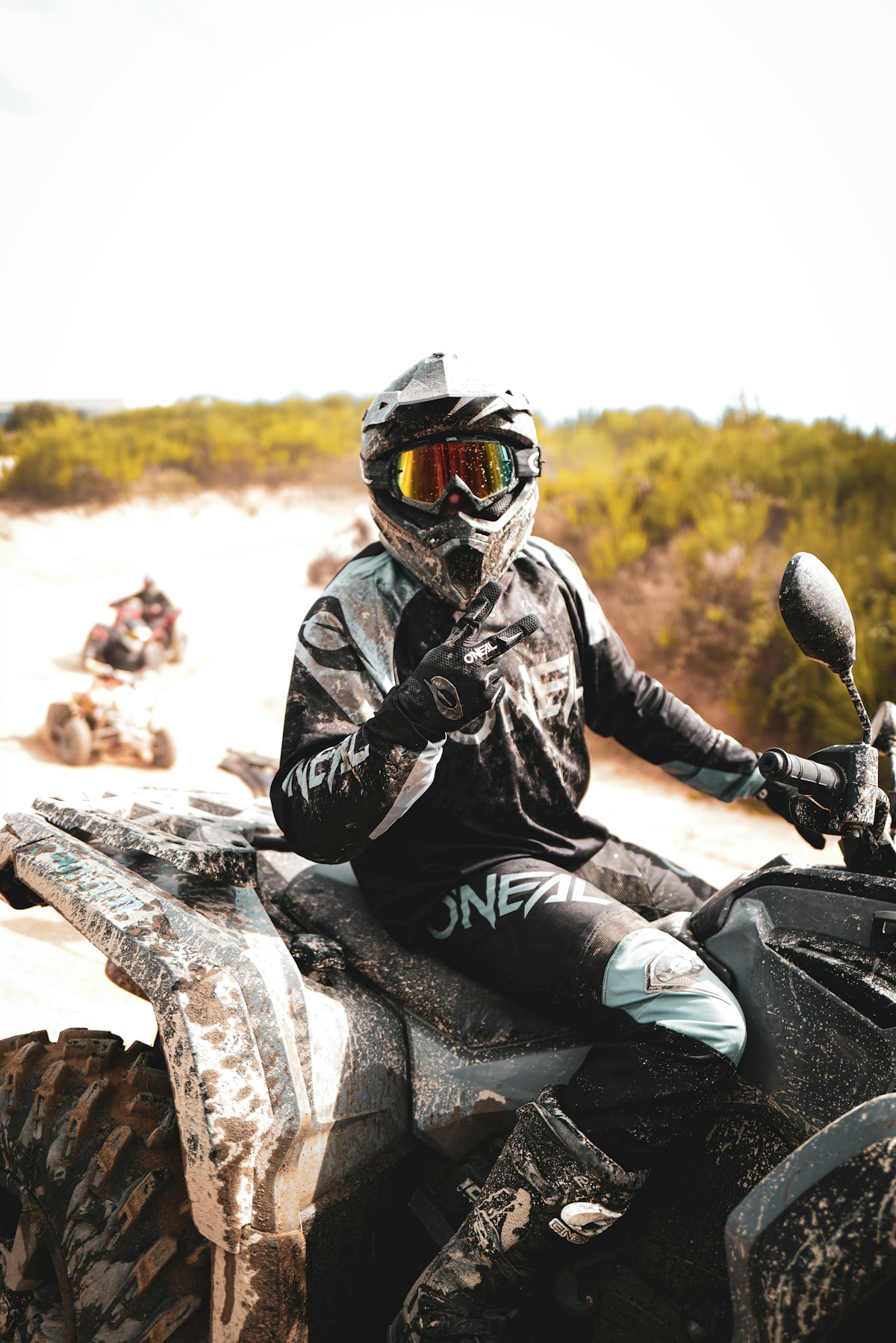 ATV rider throws up a peace sign mid ride