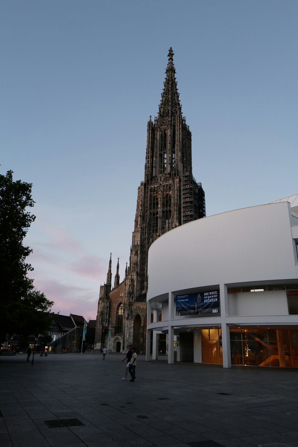 a large cathedral towering over a city next to a tall building