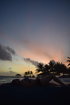 A relaxed individual enjoying a sunset on the beach, symbolizing financial freedom