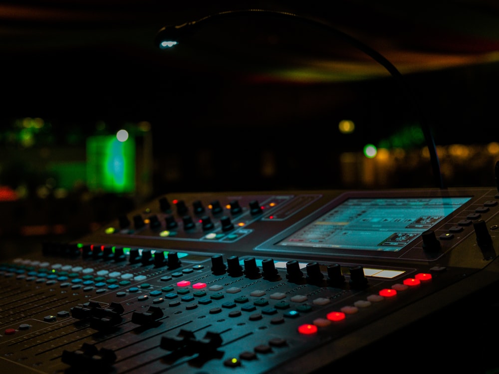 a sound mixing console in a dark room