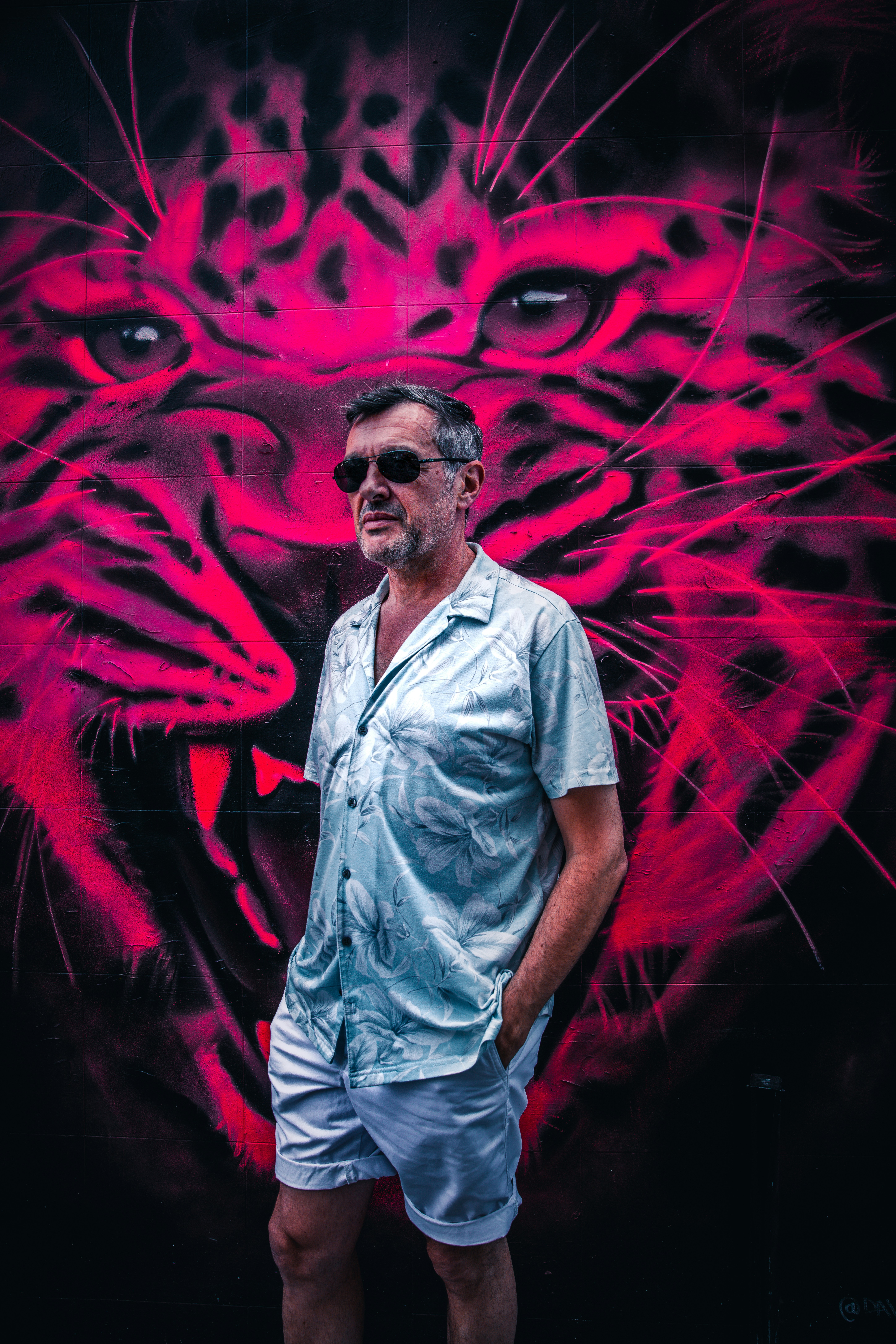 Un homme debout devant une peinture d’un tigre