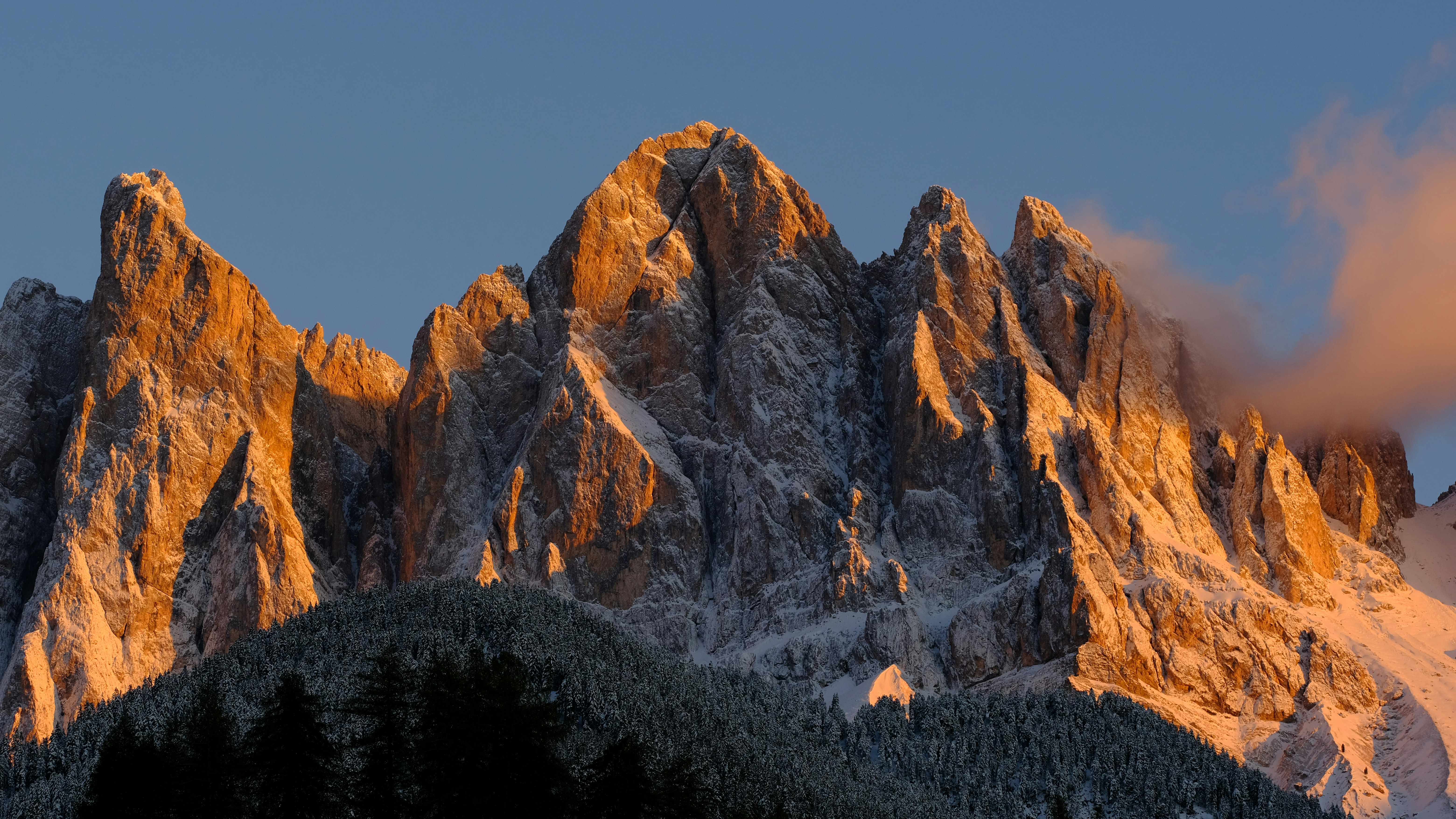a very tall mountain covered in snow under a cloudy sky