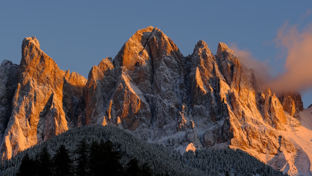 a very tall mountain covered in snow under a cloudy sky