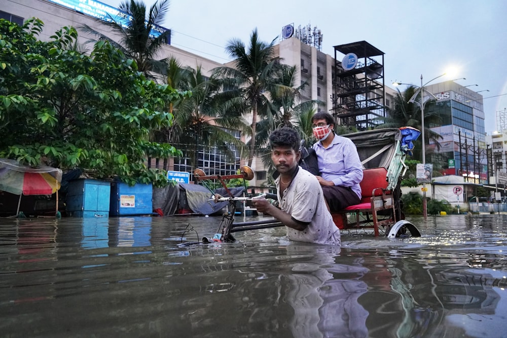 a couple of men standing in a flooded street
