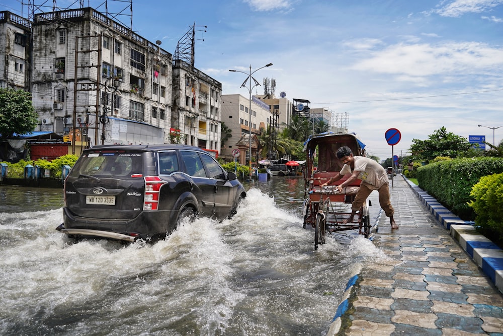 a man pushing a wagon through a flooded street