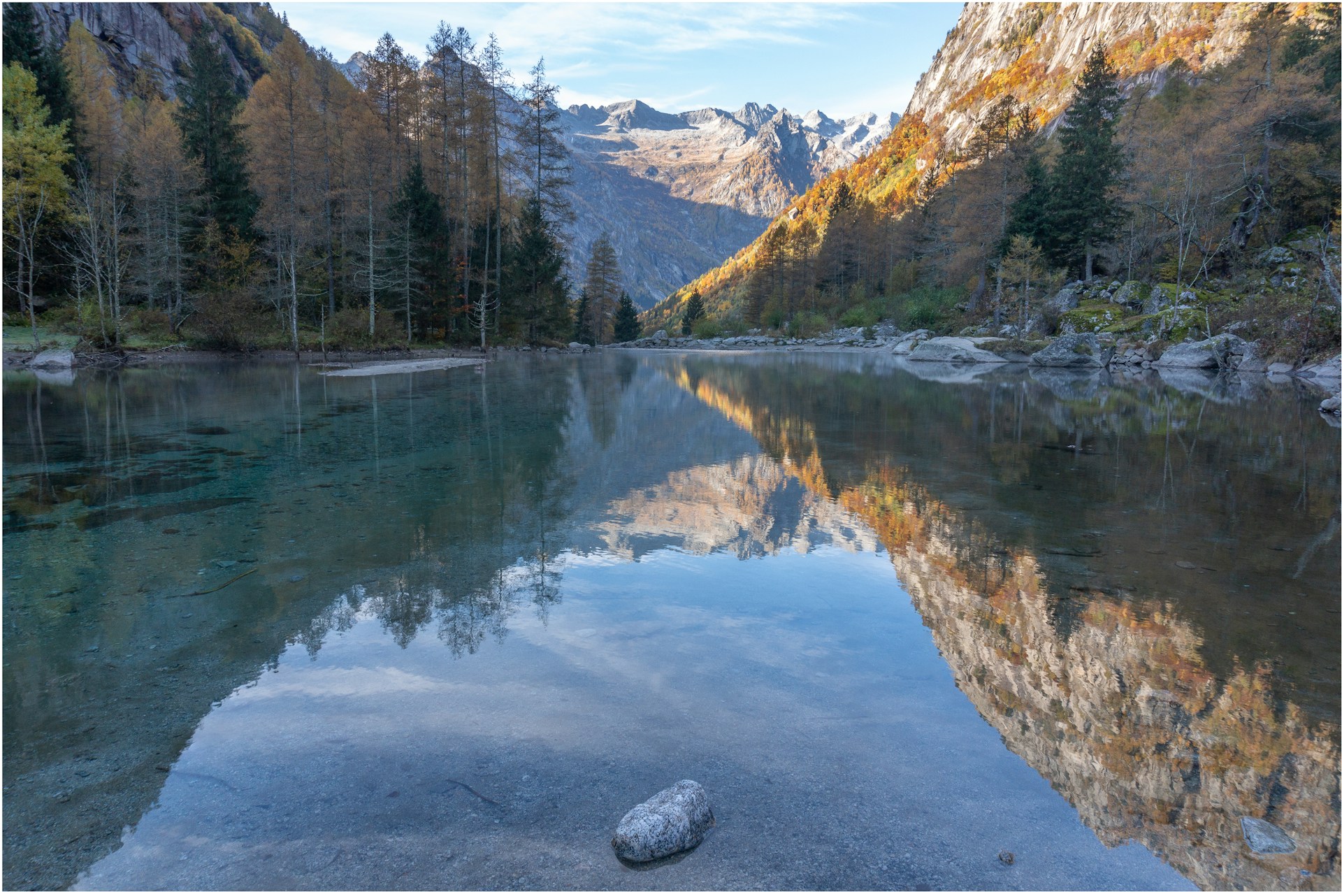 A peaceful moment by a mountain lake in Hokkaido, with autumn leaves reflecting in the crystal-clear water.