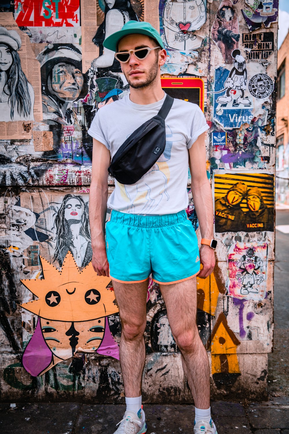 a man standing in front of a wall covered in graffiti