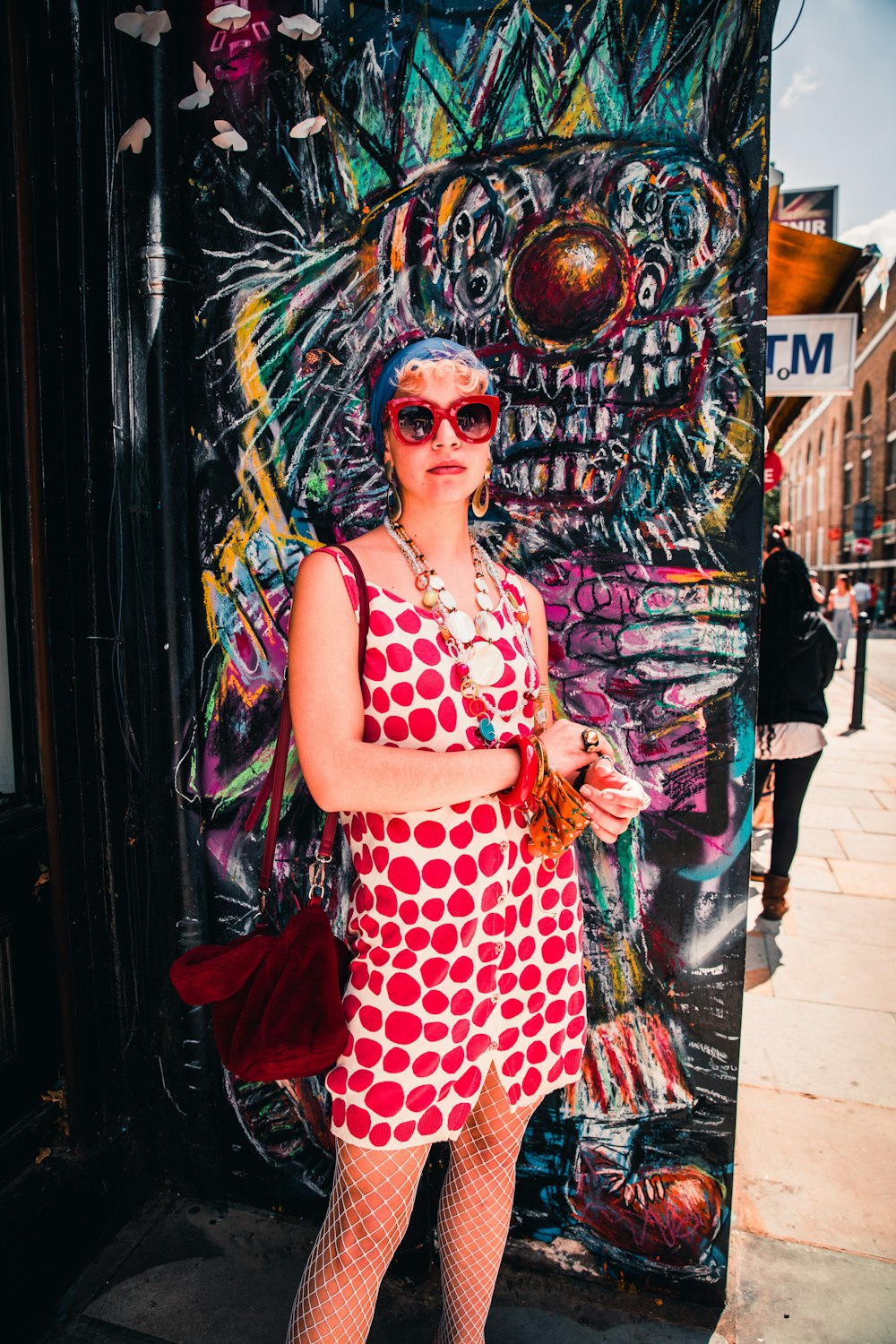 a woman standing in front of a wall covered in graffiti