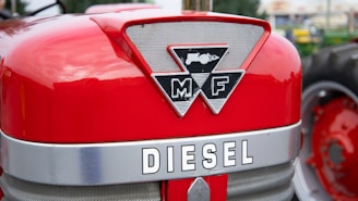 a close up of the emblem on the front of a red tractor