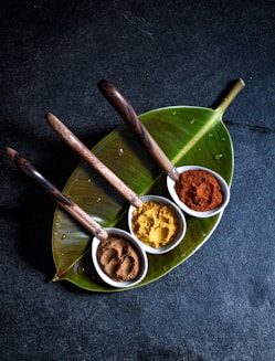 a plate with three bowls of spices on it
