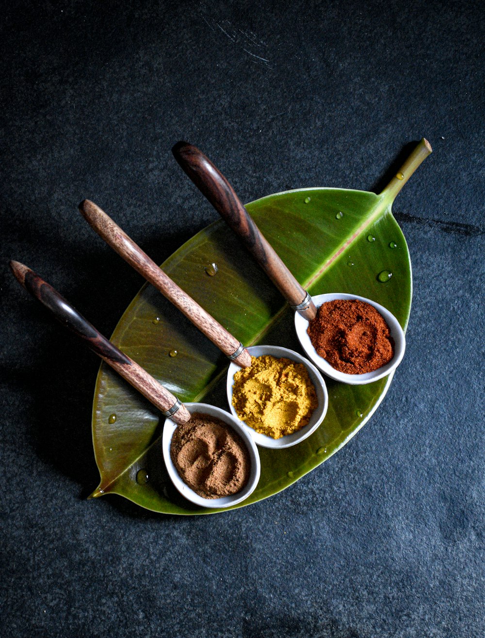 a plate with three bowls of spices on it