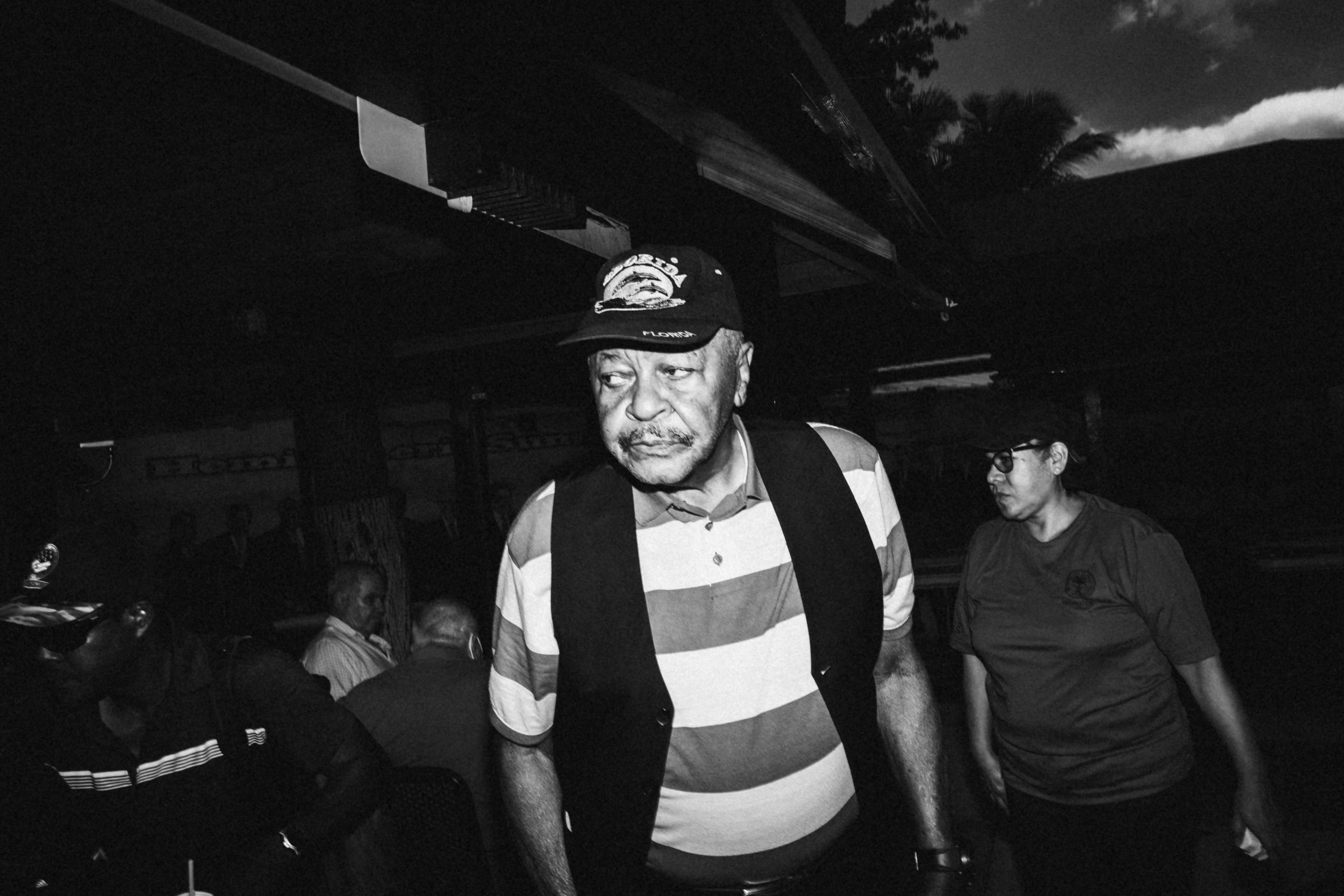 a black and white photo of a man wearing a hat