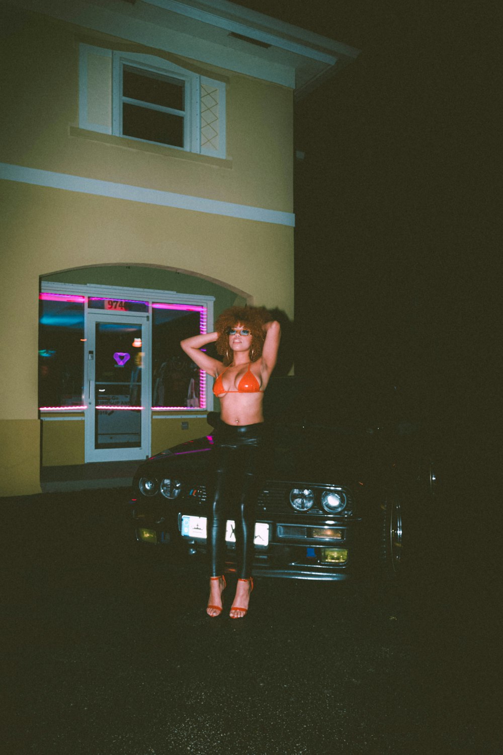 a woman standing on top of a car in front of a building