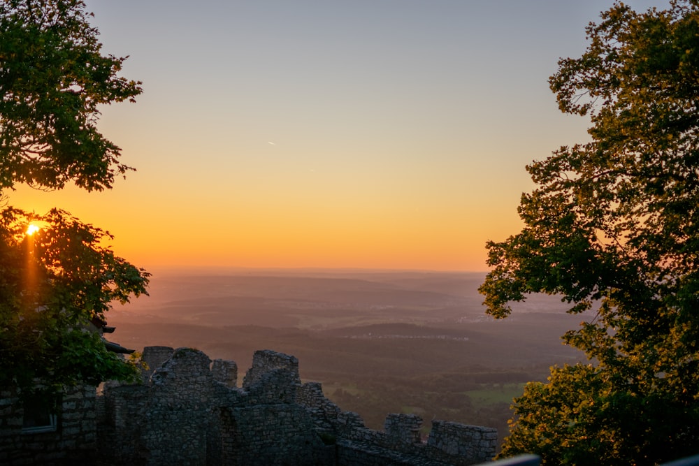 the sun is setting over a castle wall