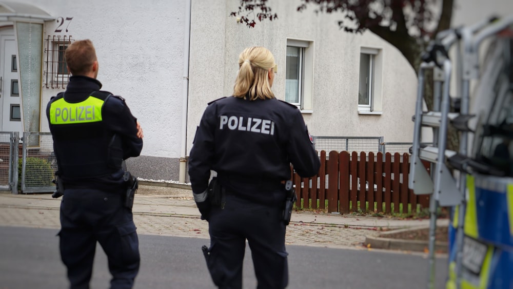 two police officers standing in front of a house