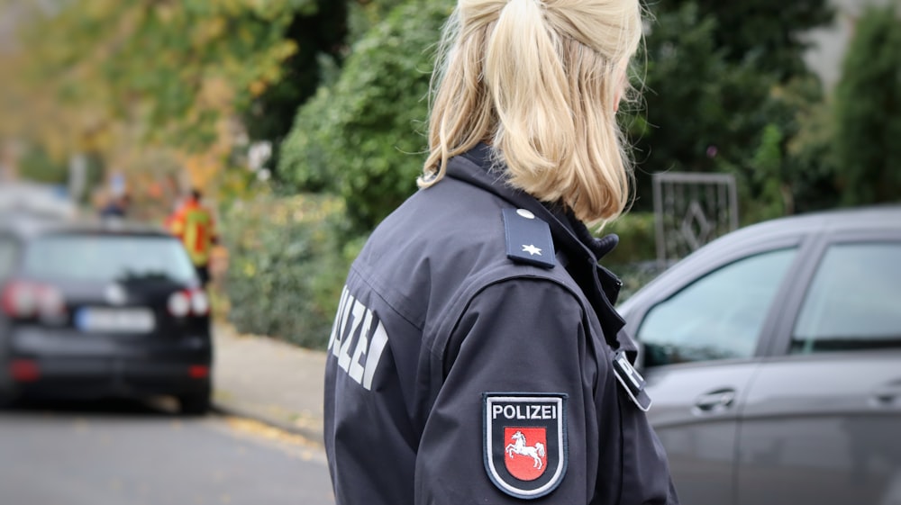 a woman in a police uniform standing on the side of the road