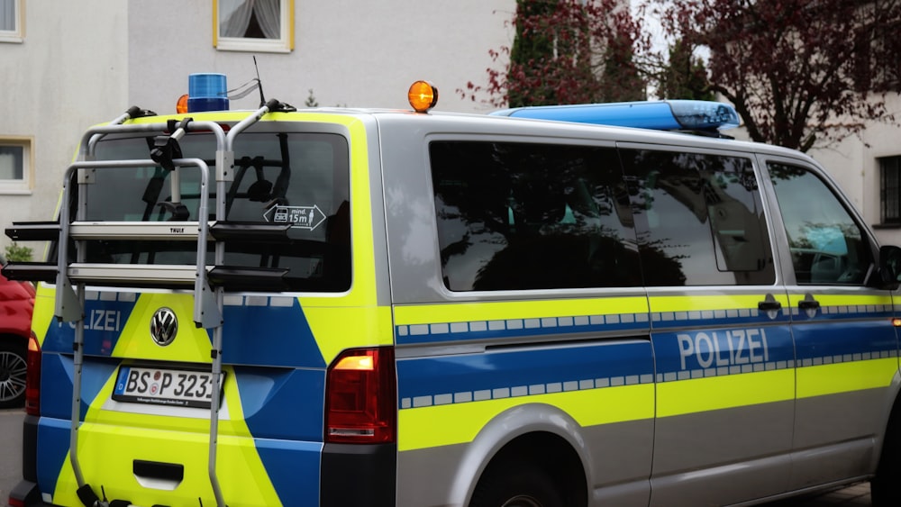 a yellow and blue police van parked on the side of the road